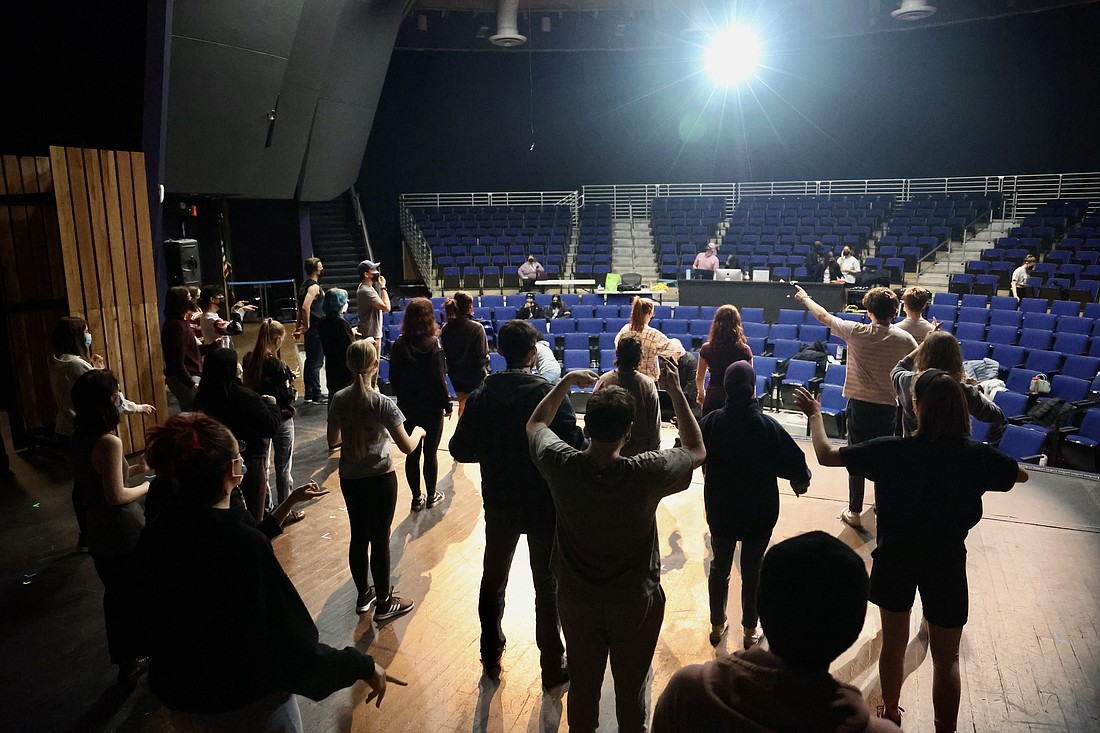 The cast of "Big Fish" does a series of vocal and physical warm ups before diving into rehearsal on Feb. 24.