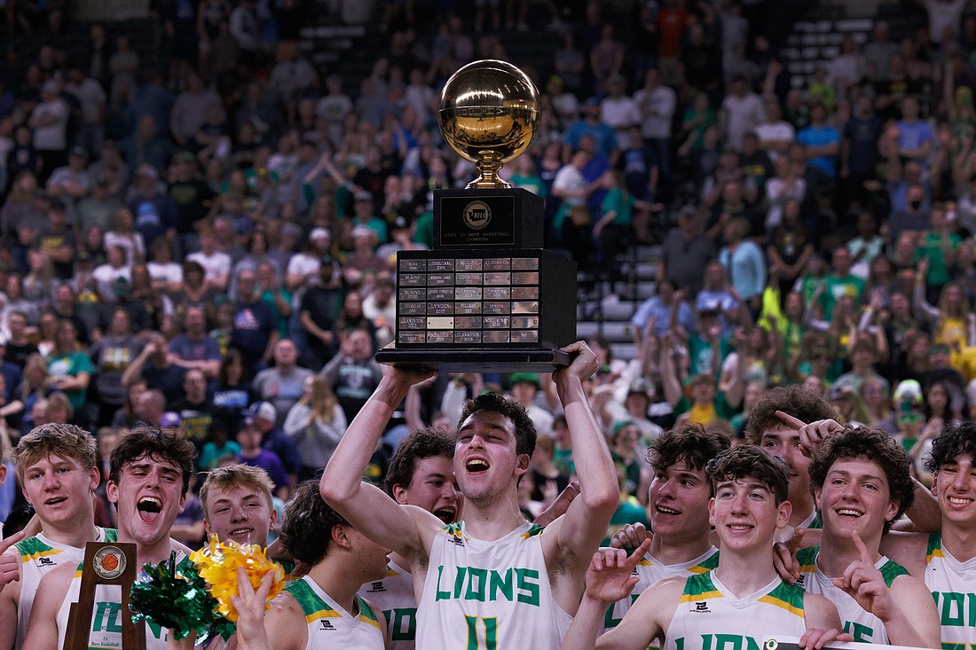 Lynden players celebrate with the championship trophy after beating Pullman 51-34 in the 2A state championship game on March 5.