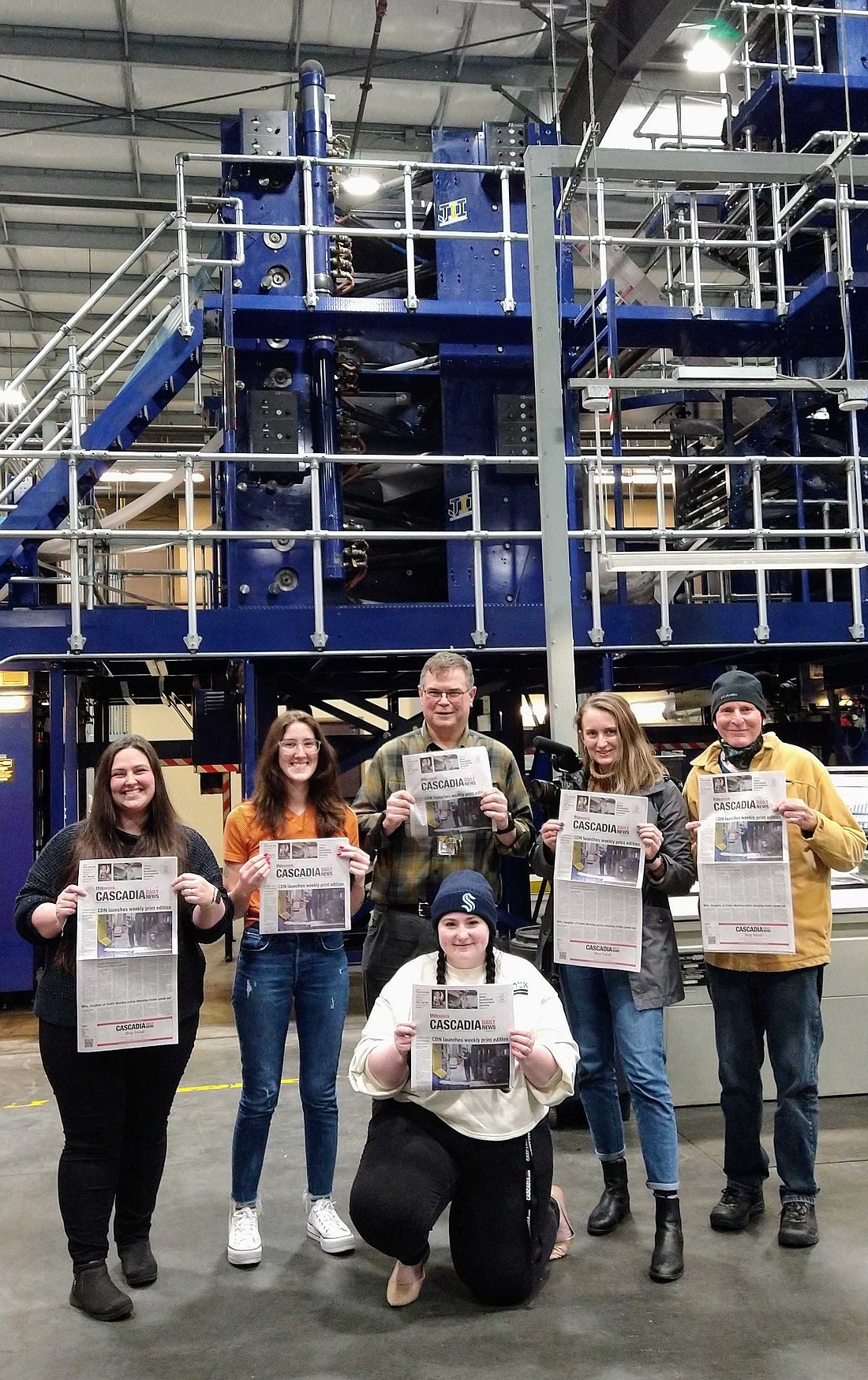 CDN staffers hold up the first copy of the Cascadia Daily News at Skagit Publishing on March 1.
