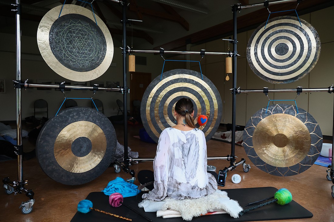 Kristi Moseley sits among her arrangement of Chinese wind gongs on March 18.