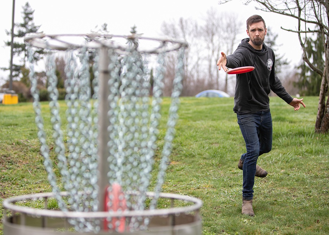 Kyle Miller throws a disc on March 22 into one of the baskets he handcrafted and placed on the Bellingham Technical College campus. Miller is a pipe-welding instructor and constructed the baskets out of scrap metal in the shop.