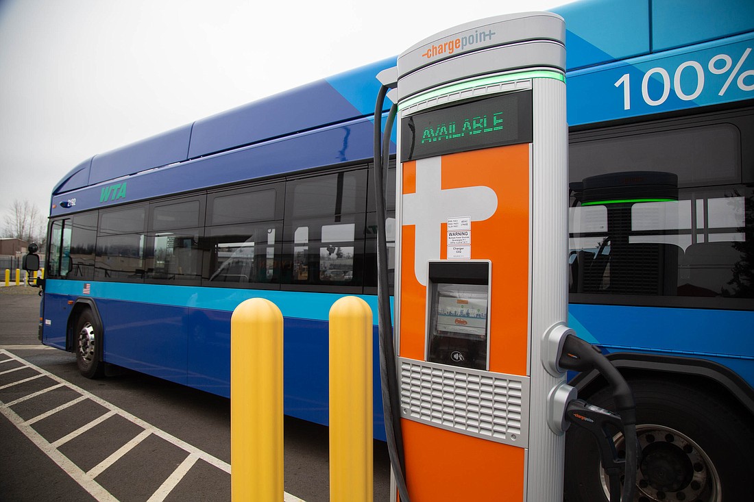 One of two Whatcom Transportation Authority all-electric buses sits at a charging station at the agency's Bakerview Spur headquarters. Software problems have repeatedly taken the electric buses off the road.
