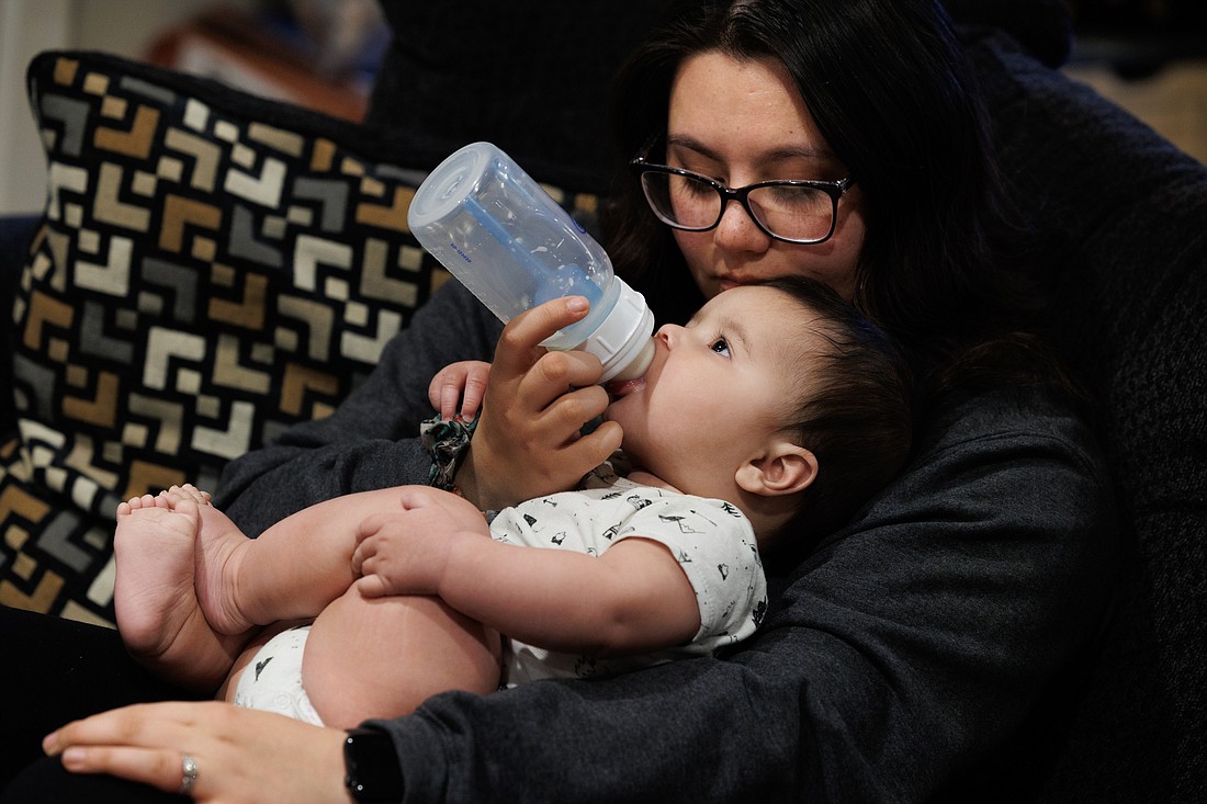 Callie Smith bottle feeds Caden, 6 months, with formula on May 12. Smith is struggling to find specific baby formulas due to an ongoing shortage.