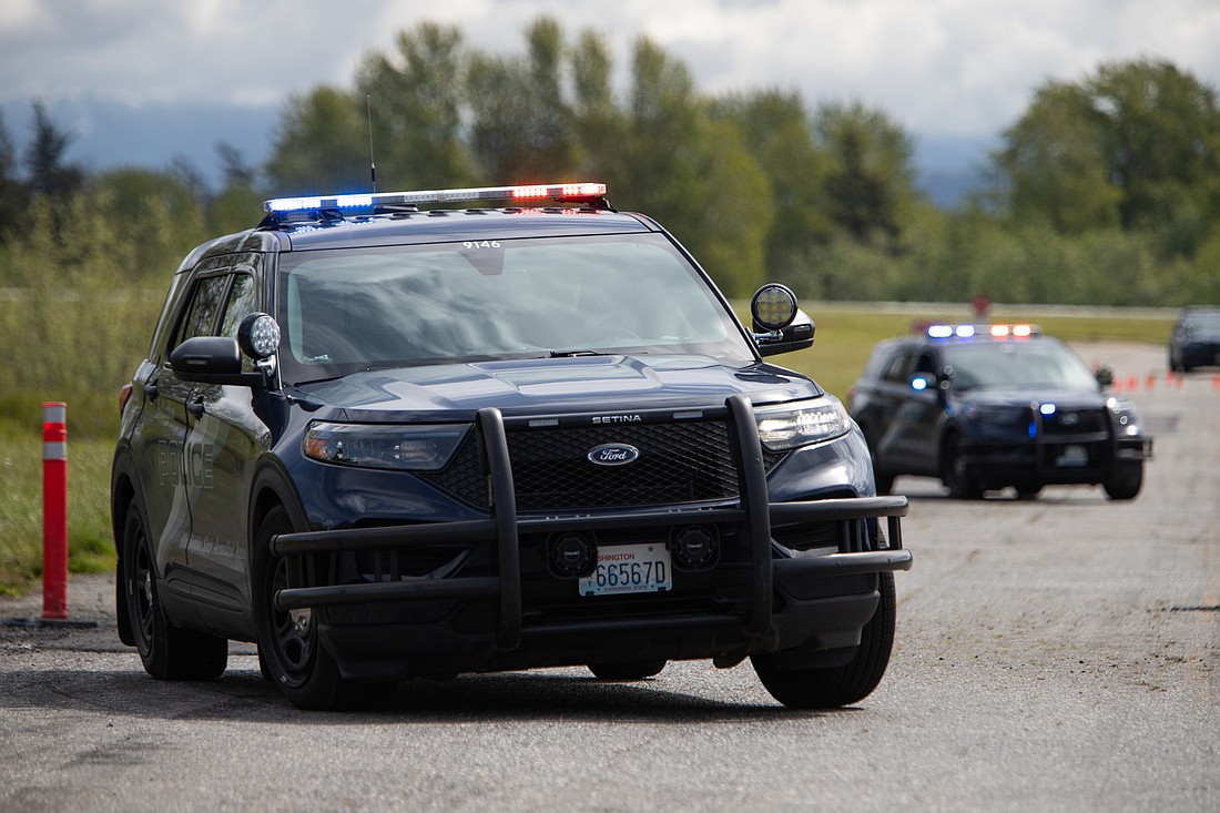Two Bellingham Police Department cruisers quickly weave between cones on the old Bellingham Airport runway during a training on May 13.