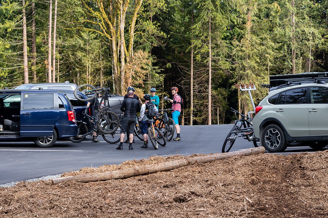 A group of mountain bikers return to their cars at the new parking lot after riding trails at Galbraith Mountain.