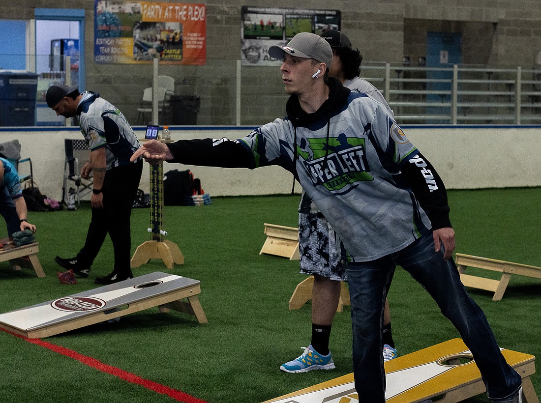 Tyler Luce tosses his beanbag during a cornhole tournament at the Bellingham Sportsplex on May 6. Luce, like many other participants, has his own custom-made jerseys that he wears to tournaments.