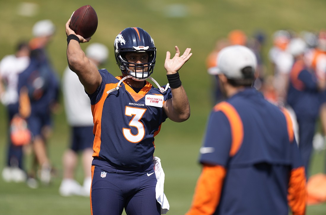 Denver Broncos quarterback Russell Wilson takes part in drills at the NFL football team's voluntary minicamp Wednesday, April 27, 2022, at the team's headquarters in Englewood, Colo.