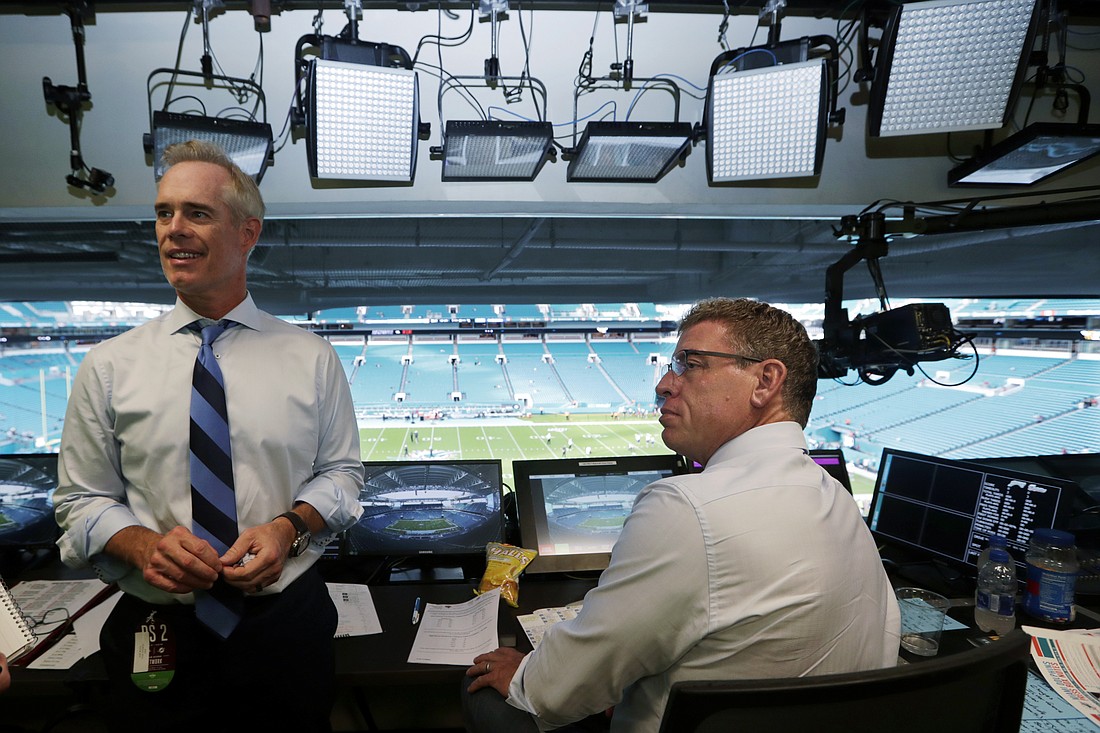 Fox Sports play-by-play announcer Joe Buck, left, and analyst Troy Aikman work in the broadcast booth before a preseason NFL football game between the Miami Dolphins and Jacksonville Jaguars in Miami Gardens, Fla., Aug. 22, 2019. On May 16 Buck and Aikman made their first trips to ESPN headquarters in Bristol, Conn., to meet with executives and their future co-workers as preparations for the upcoming season began to ramp up.