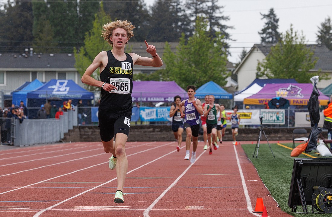 Sehome's Zack Munson holds up a finger as he takes first place in the 3200-meter race during the 2A state track championships on May 28 in Tacoma.