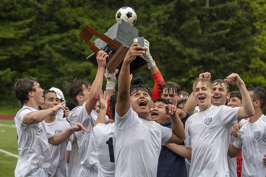 Squalicum boys soccer players celebrate while holding the 2A state championship trophy after defeating Burlington-Edison 5-0 in the title game in Tumwater on May 28.