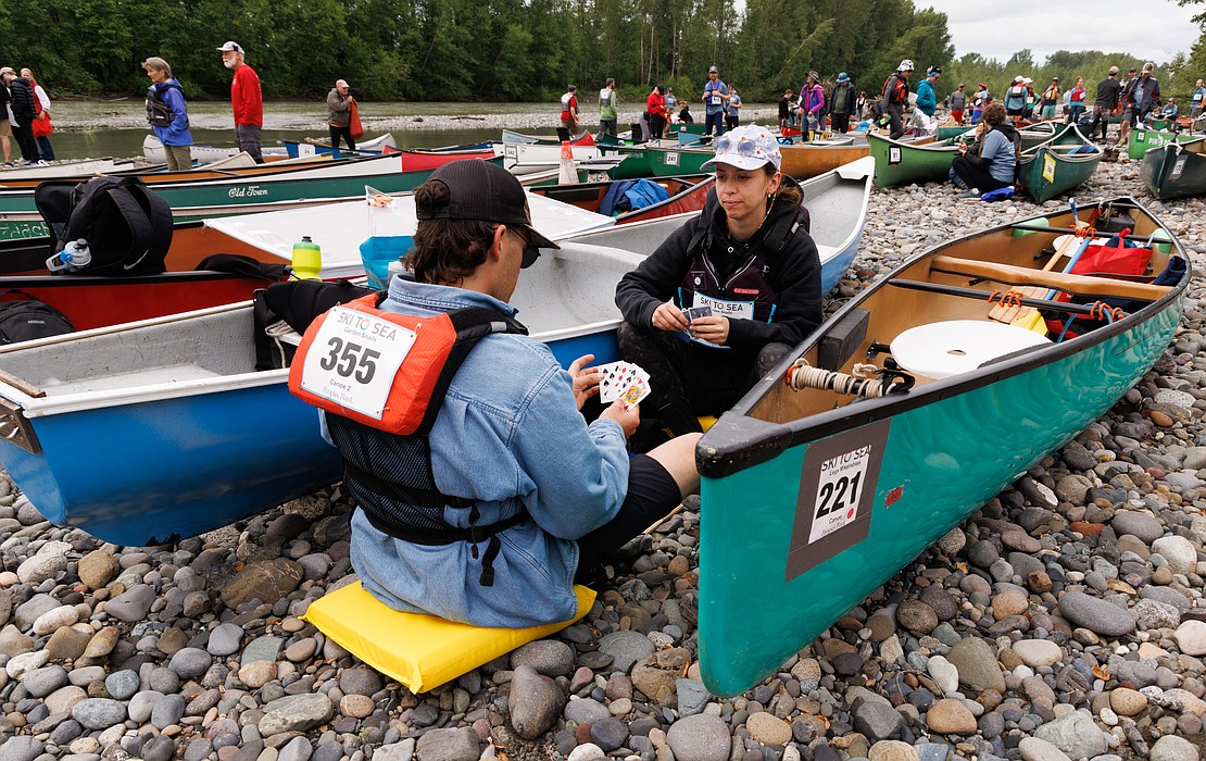 Cole Wilson and Lydia Schulz play cribbage as they wait for their team number to be called at the canoe start in Everson.