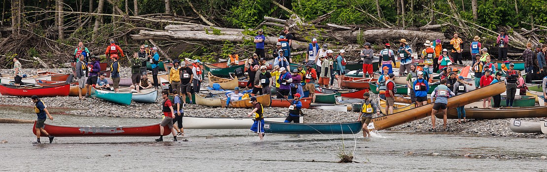 Competitors carry their canoes into the river as others wait for their turn to race during Ski to Sea on May 29 in Everson.