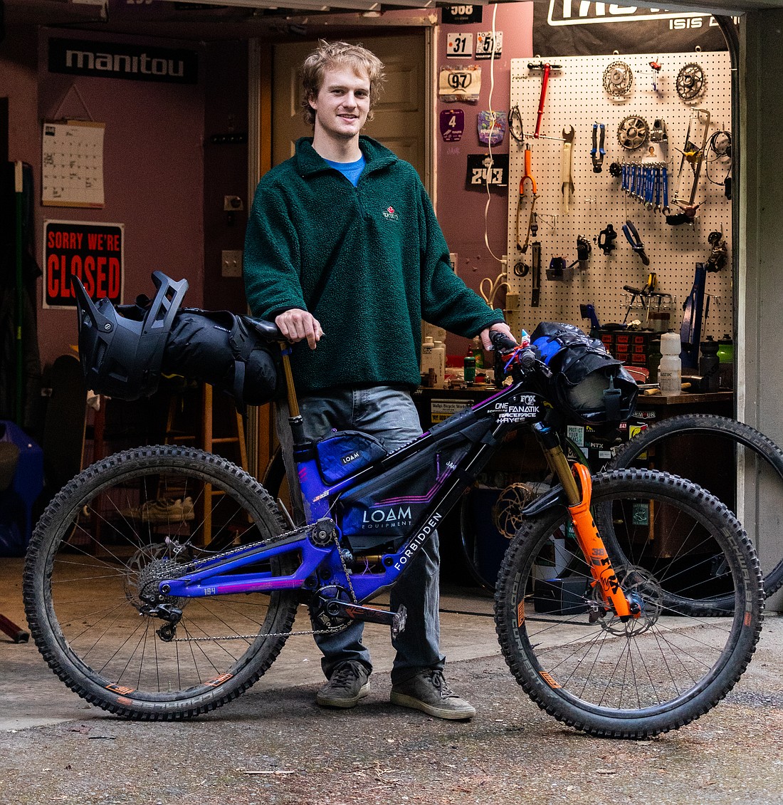 Eric Olsen stands in front of his workshop on May 30 with the enduro bike he will be competing and traveling Europe on. Olsen's trip will take him to race in three different enduro mountain bike competitions in three different countries.