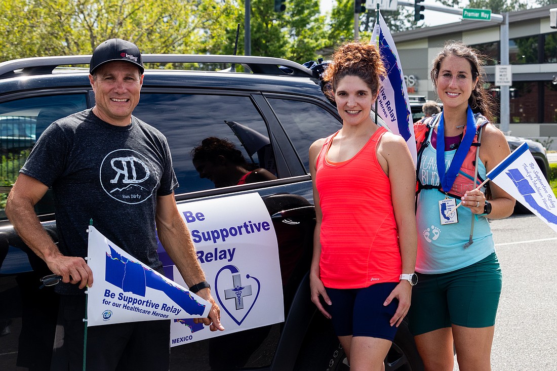 From left, Steve Fink, Sara Reid and Tanya Gallo meet at a trade-off location for Reid to complete her part of the second leg of the relay on June 5.