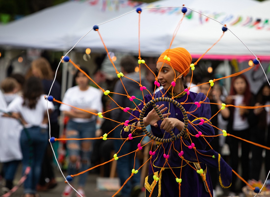 Abjit Kahur spins a chaker during a Sikh group performance at the Birchwood International Market on June 17.
