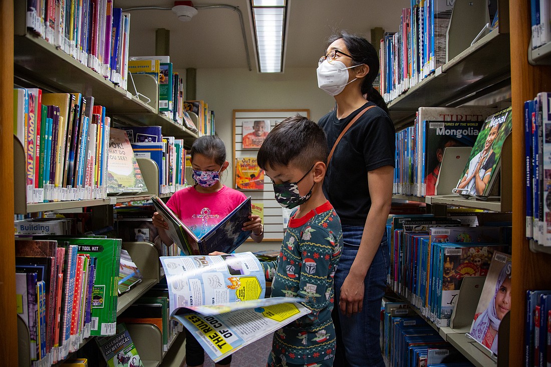 From left, Emily Henry, 9, Isaac Henry, 7, and Rhea Medrano explore the shelves of the children's section at the Bellingham Public Library on June 16. As part of Summer Reading 2022, the central library will pair with the Whatcom County Library System to help make reading accessible to all.