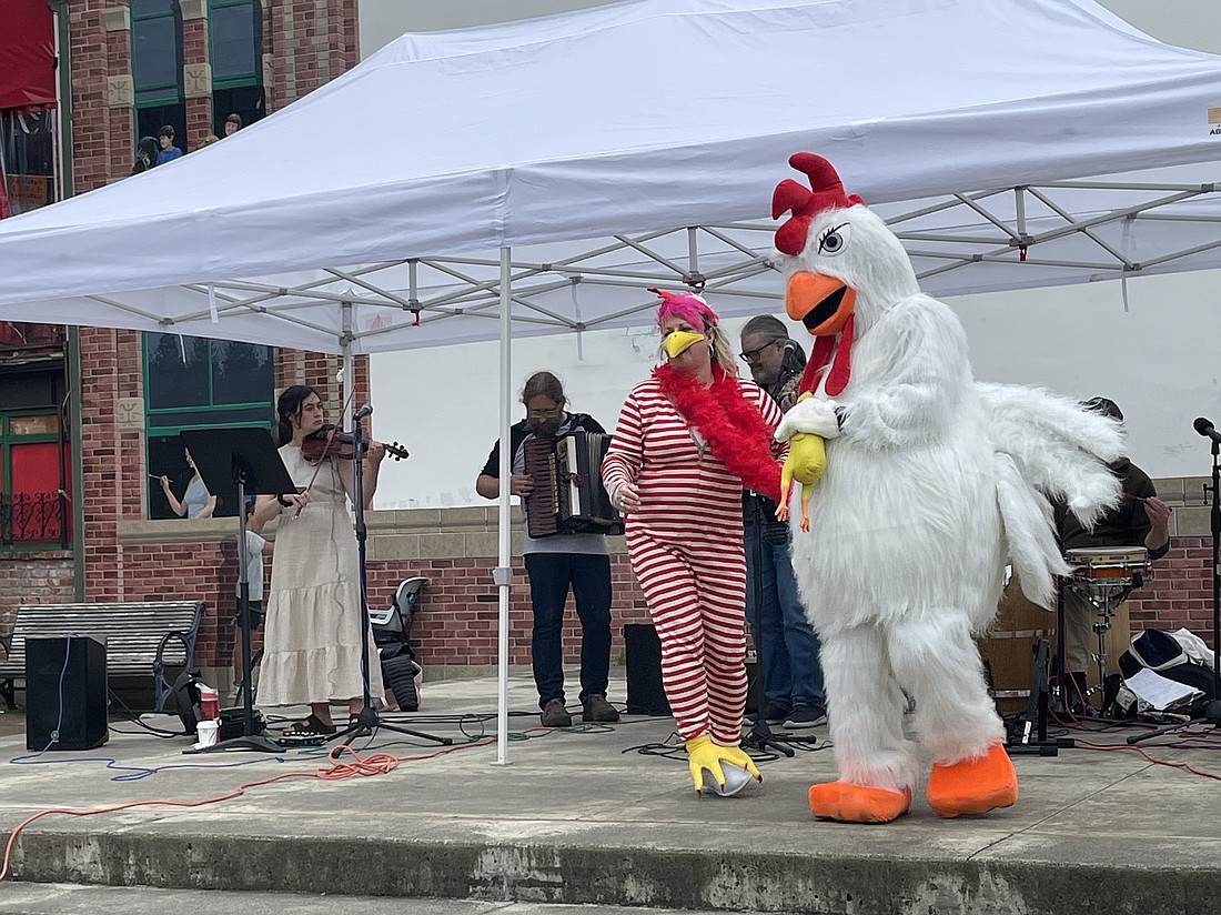 Former Bellingham City Council member Pinky Vargas does the "Chicken Dance" with Fairhaven Chicken Festival mascot Dylan Hartmann during the inaugural event Saturday,June 18 at the Fairhaven Village Green.