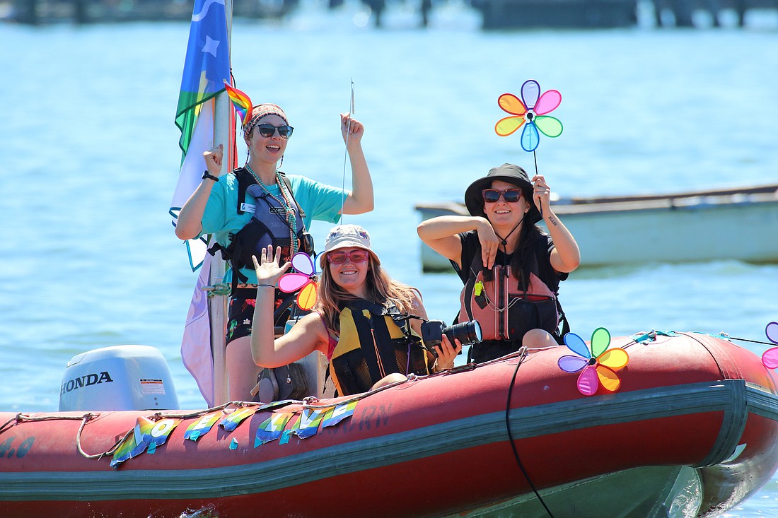 From left, Christine McCormick, Megan Bullard and Angela Morovic of the Community Boating Center staff the safety boat at Bellingham’s Pride Paddle on Sunday June 26.
