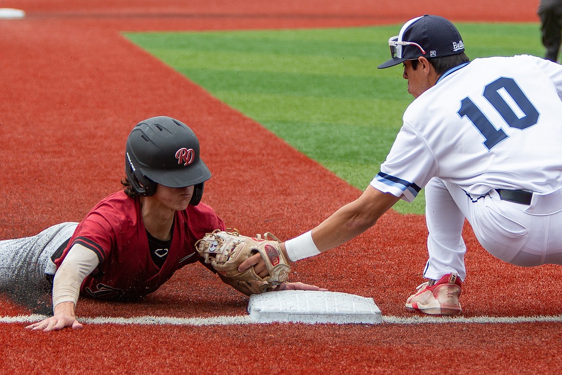Bellingham Bells' Christopher Campos attempts to tag out the Redmond Dudes' Alexy Hussey at third base during their game at Joe Martin Field on July 4. The Bells lost to the Dudes 6-4.