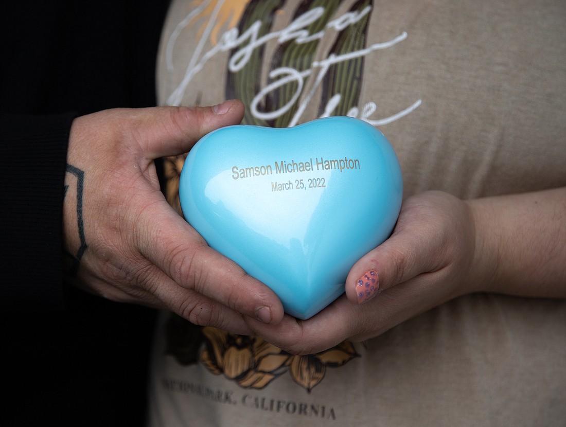 Dylan, left, and Allison Hampton hold a heart-shaped urn filled with the ashes of their son, Samson Michael Hampton, who died at 21 weeks in the womb and was aborted. After learning about his passing, Allison had to wait a week before traveling to Seattle to have the fetus removed.