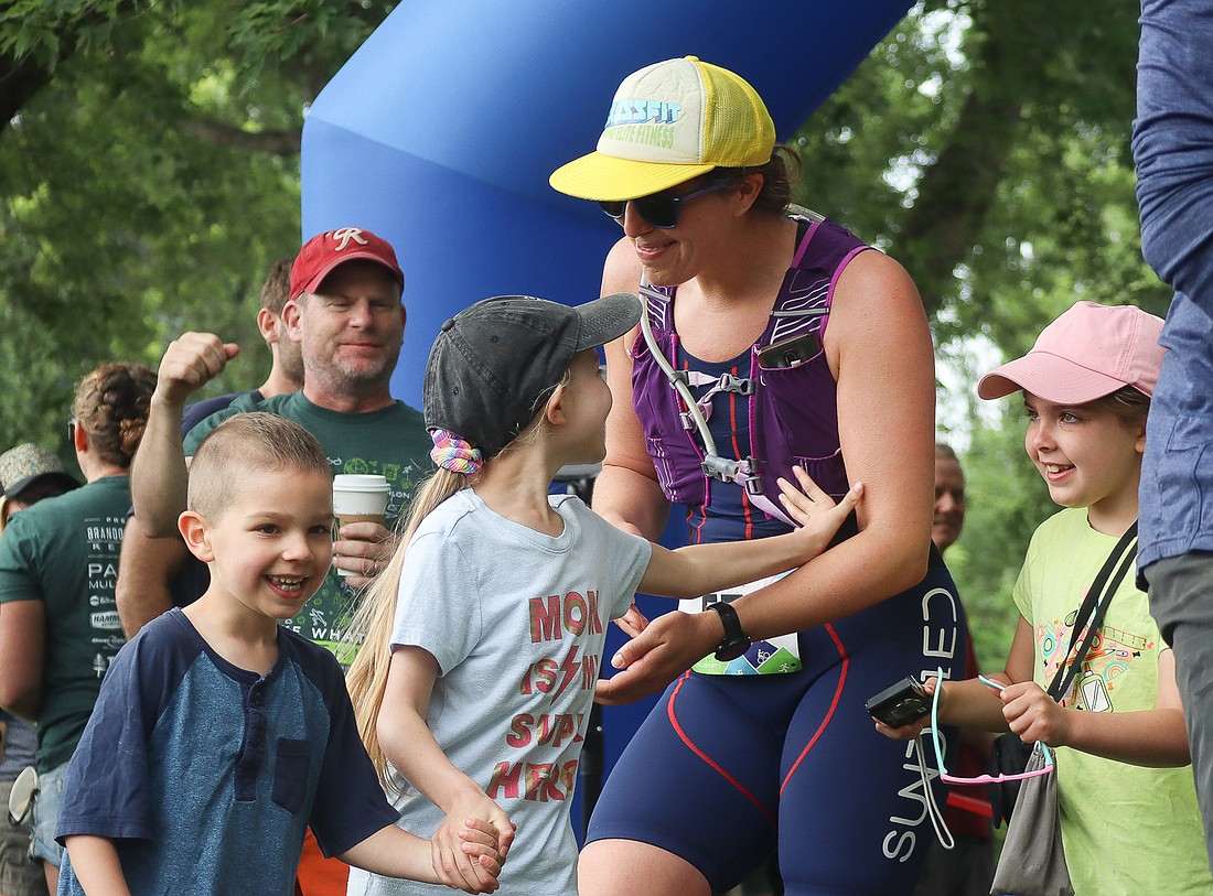 Cristina Waters celebrates finishing the Olympic distance of the Lake Whatcom Triathlon on July 9. After finishing the race, participants could pick up their finisher magnets, snacks, chocolate milk and food from two food trucks.