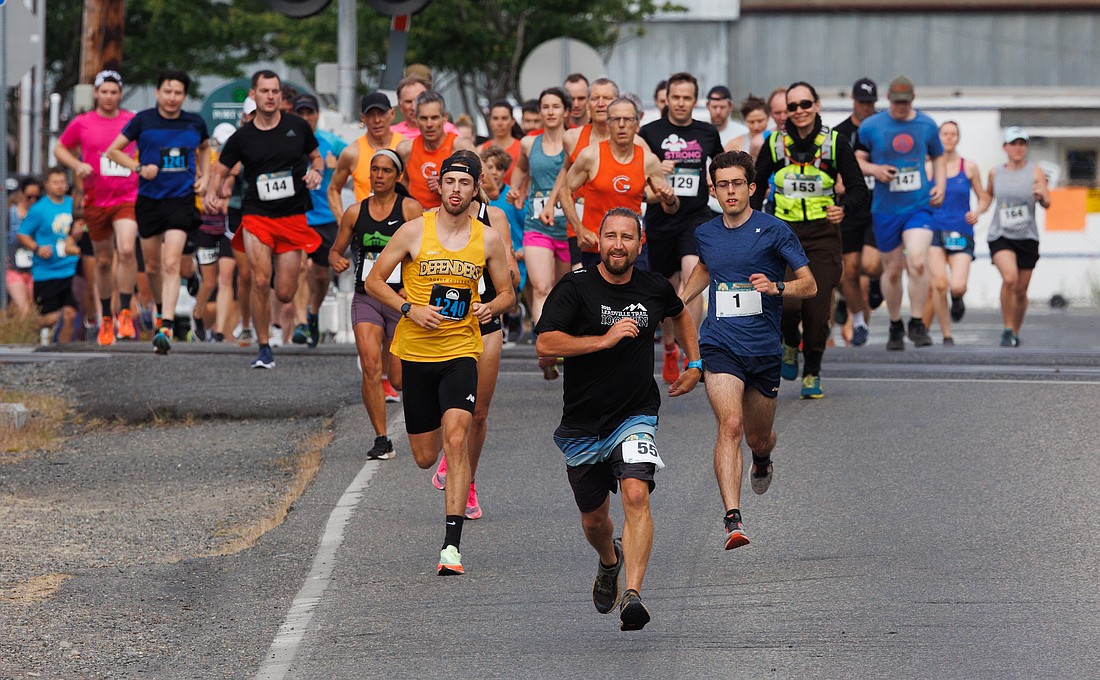 John Glinsman (55) leads the crowd of runners at the start of the 7-mile Chuckanut Foot Race from Marine Park to Larrabee State Park on July 16.
