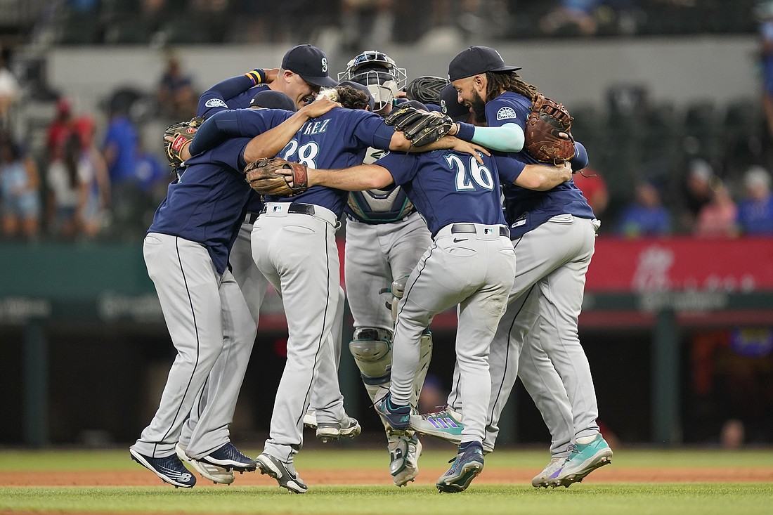 The Seattle Mariners dance in a circle after the final out of the baseball game against the Texas Rangers in Arlington, Texas, July 17. The Mariners won 6-2.
