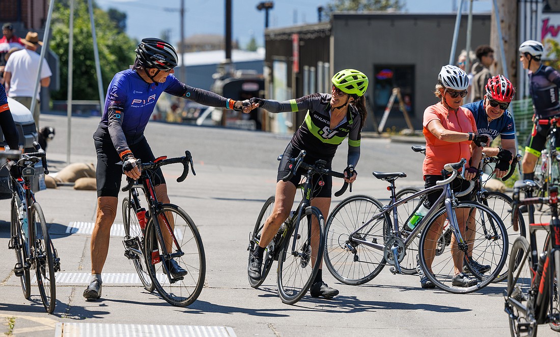 Bill MacMillan and Diane Murtha bump fists after finishing the 100-mile route of the Tour de Whatcom on July 23.