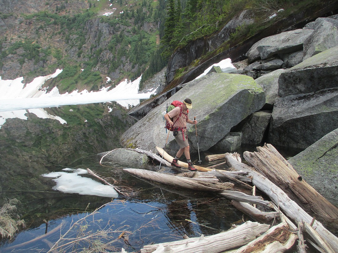 Backpacker Dave Zulinke crosses a log jam at Thornton Lake. Backcountry adventurers are increasingly adding the threat of human violence into calculations about outdoor activities. Crime in wilderness and backcountry areas is rare, but it does happen.