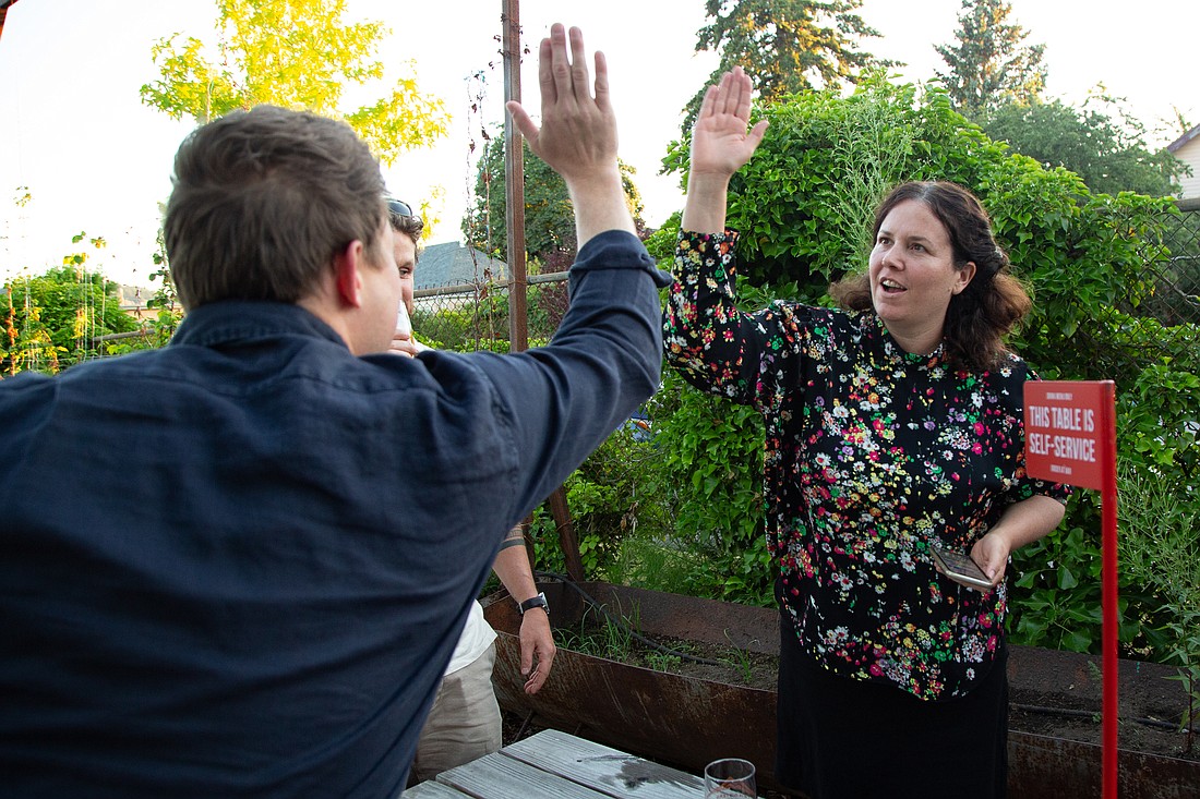 Joe Timmons, left, and Sharon Shewmake high-five after seeing the primary election returns at Twin Sisters Brewing Company on Aug. 2.
