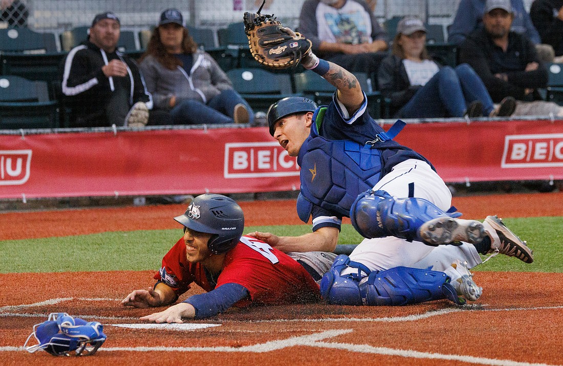 Bellingham Bells catcher Blake Conrad gets flipped around while making the out at home plate. The Bells lost to the Victoria HarbourCats 8-6 on Aug. 3.
