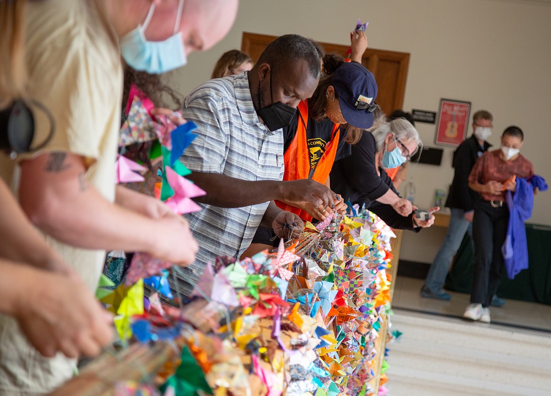 Rally attendees hang 10,000 origami butterflies over the balcony in Bellingham City Hall on Aug. 5. Community to Community Development organized the public art display to show their support for a city-funded Immigrant Resource Center.