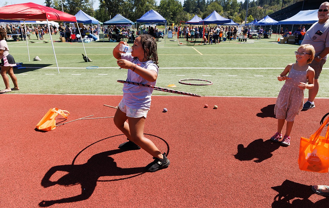 Leilani Rodriquez drinks water while hula hooping during Kids Fest at Civic Stadium on Aug. 6.