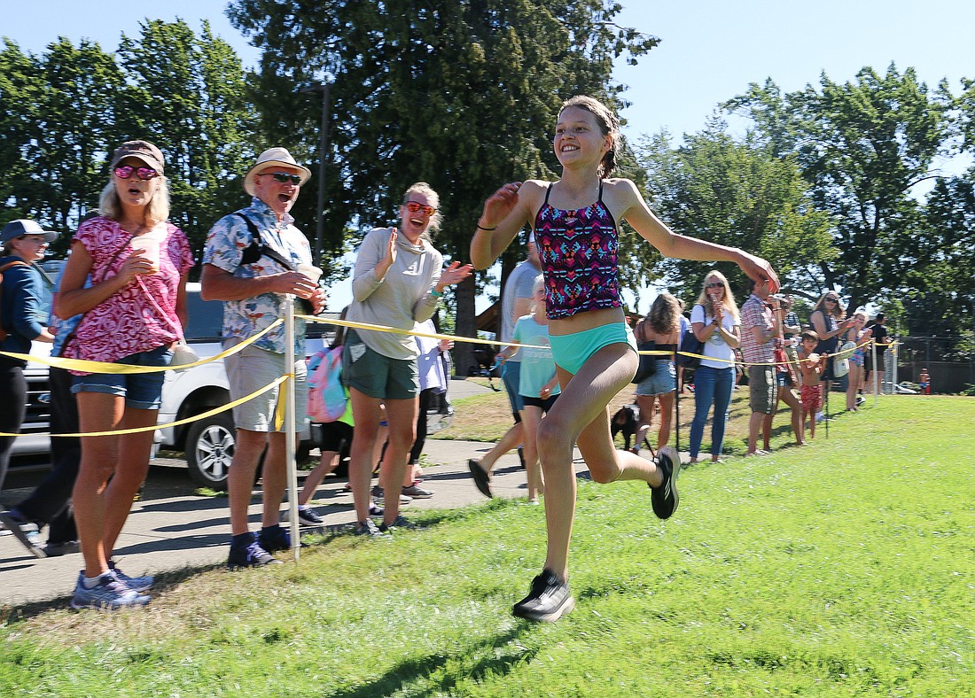 Sophia Gage sprints to the finish line, finishing first in the ages 9-10 race at the Bellingham Youth Triathlon on Aug. 7. To end the race, participants ran laps around the field outside Arne Aquatic Center, ranging from a quarter mile for the youngest group to a mile for the oldest group.