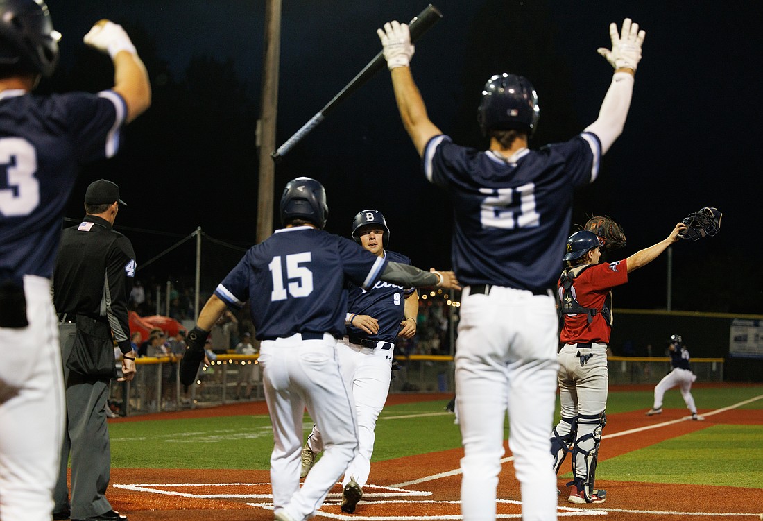 Bellingham Bells players celebrate after Jaidon Matthews (15) and Noah Meffert (9) cross home plate to put the Bells ahead in the eighth inning. The Bells beat the Victoria HarbourCats 4-2 in a West Coast League playoff game at Joe Martin Stadium on Aug. 10.