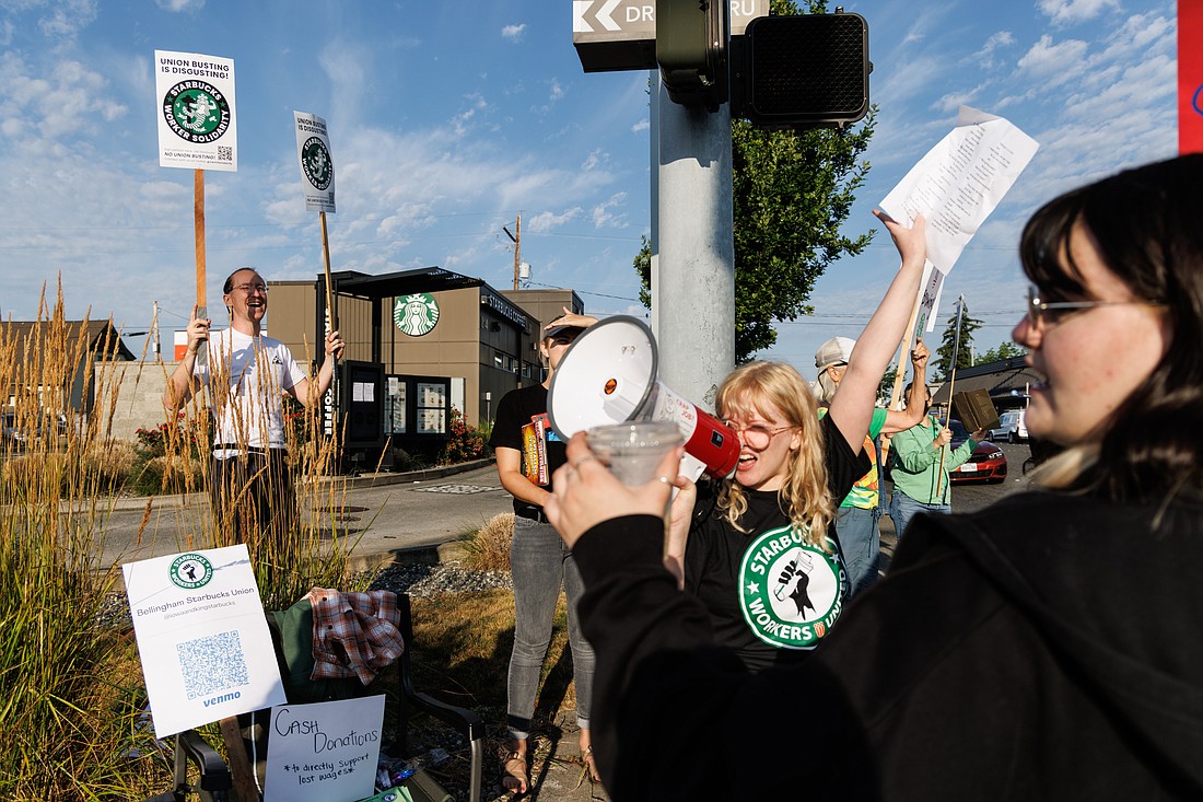 Using a megaphone, Heather Bergeson cheers on unionized Starbucks workers and their supporters as they strike outside the Iowa Street location on Aug. 12.
