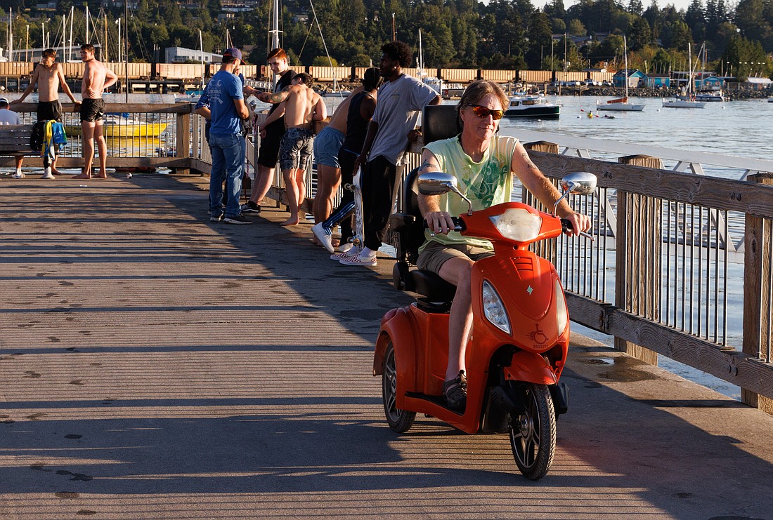 Todd Sharp drives his e-wheel along Taylor Dock on Aug. 17. Sharp, who cannot walk due to Lyme disease, was able to drive to the waterfront from Bloedel Donovan Park using trails along the route.