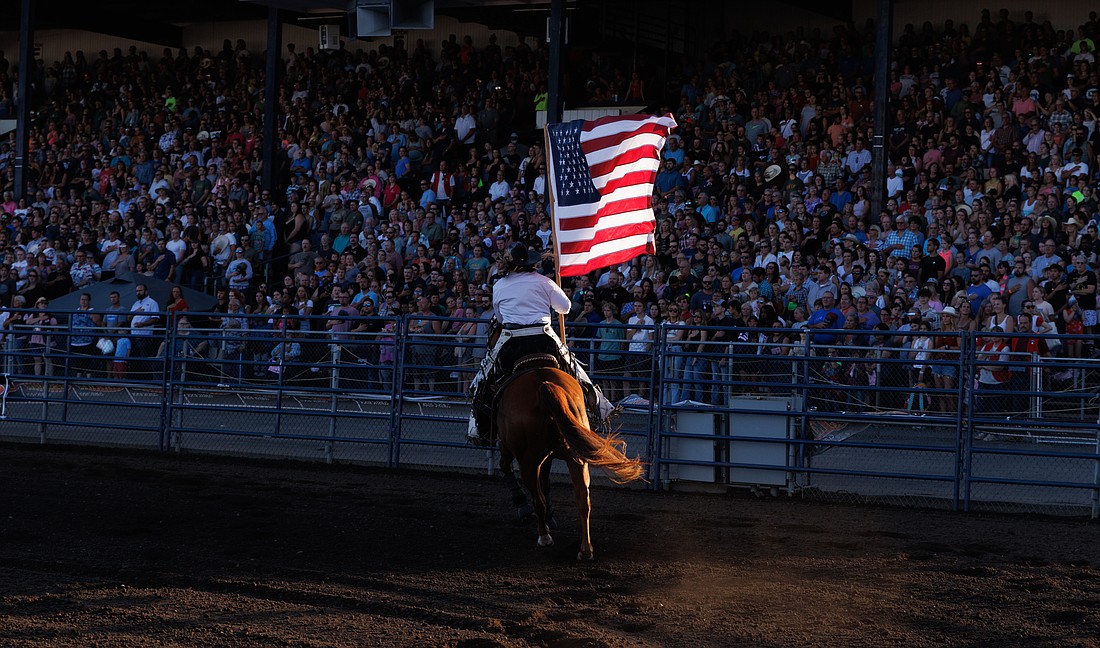 A rider parades the American flag around the arena during the National Anthem at the Lynden PRCA Rodeo on Aug. 15.