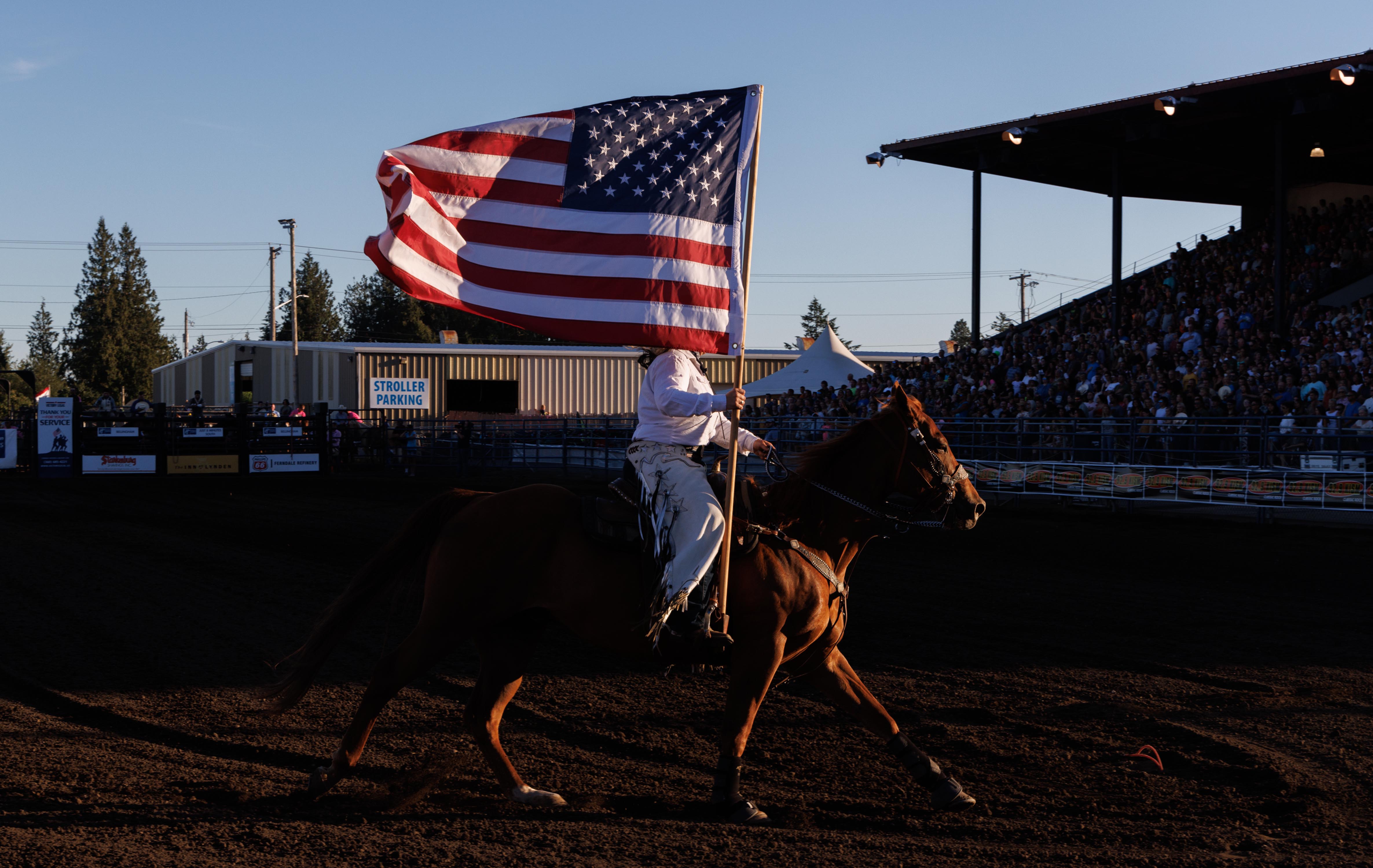 A rider parades the American flag around the arena during the National Anthem at the Lynden PRCA Rodeo on Aug. 15.