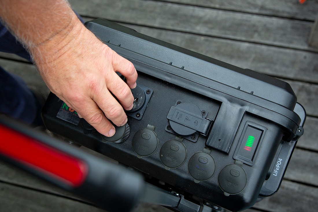 Paul Shmotolokha, chairman and CEO of New Use Energy, opens different plugs and ports on a portable power station housed in a hard-shell roller suitcase at his home in Bellingham on Aug. 26. Shmotolokha, a Ukrainian-American, sends the batteries along with solar panels and other gear to aid humanitarian efforts in Ukraine.