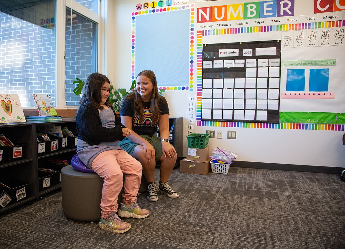 Kindergartener Claire Hagan, left, tries out a "wiggle seat" while getting a tour of her new classroom from teacher Kalli Kritsonis at Sumas Elementary on Aug. 29. The school hosted a welcome back event prior to the start of school for families and teachers to reunify after months of separation caused by the flooding.