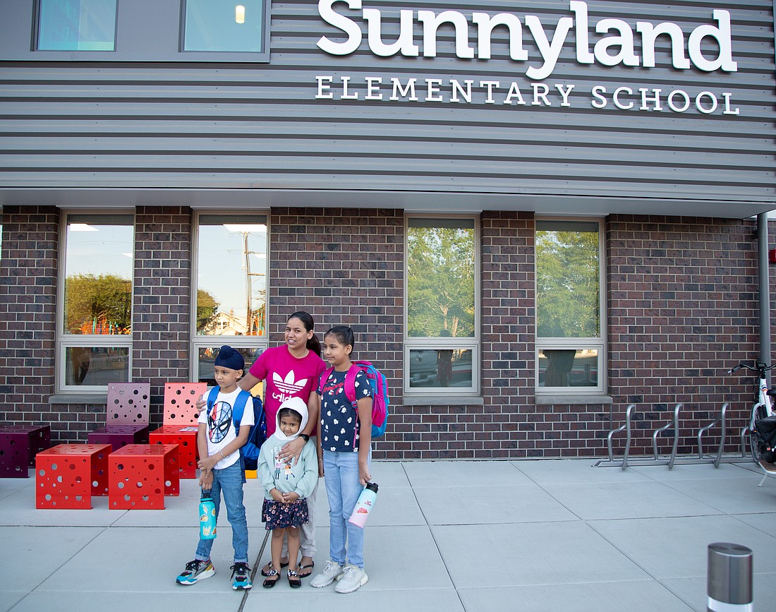 Satinder Kaur, center, takes a photo with her kids Ajai, left, and Ganeev, right, on their first day during drop-off at Sunnyland Elementary on Aug. 30.