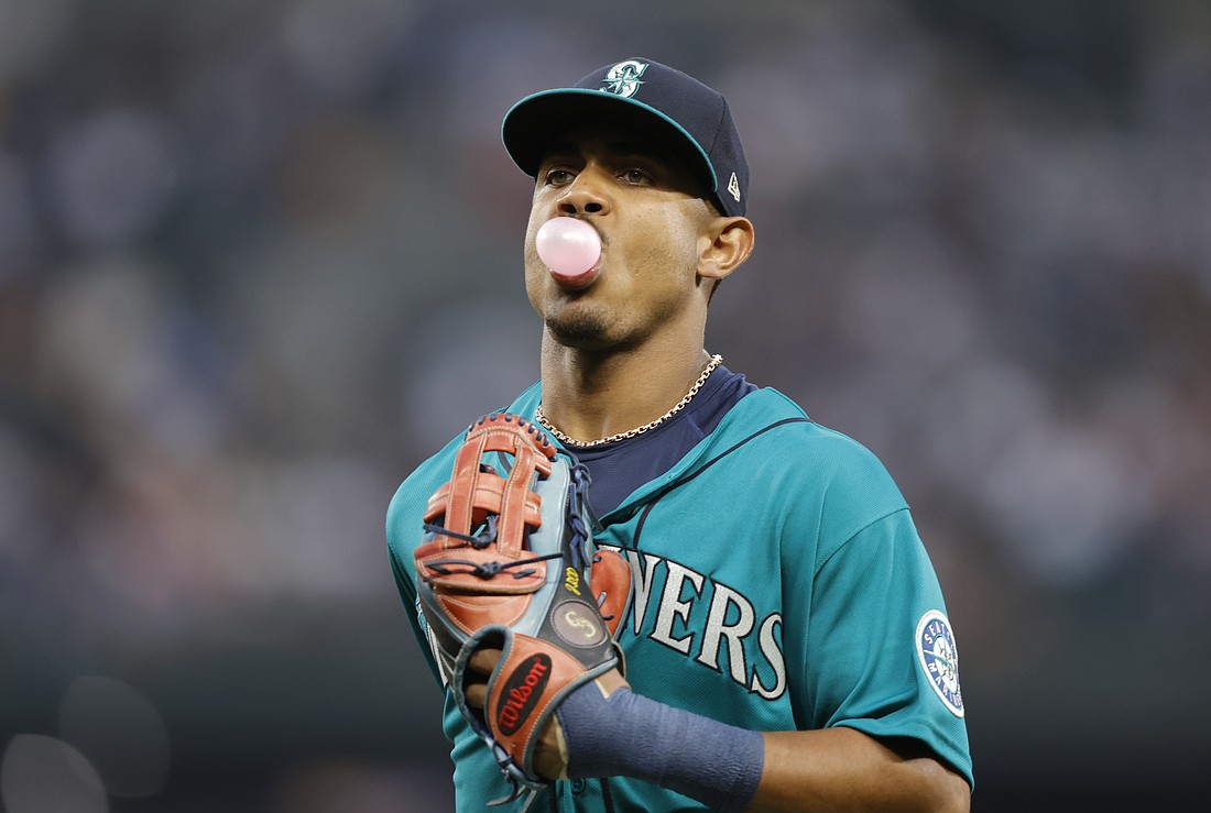 Seattle Mariners' Julio Rodriguez blows a bubble as he runs to the dugout while leaving the field during the second inning of a baseball game against the Cleveland Guardians on Aug. 26 in Seattle.