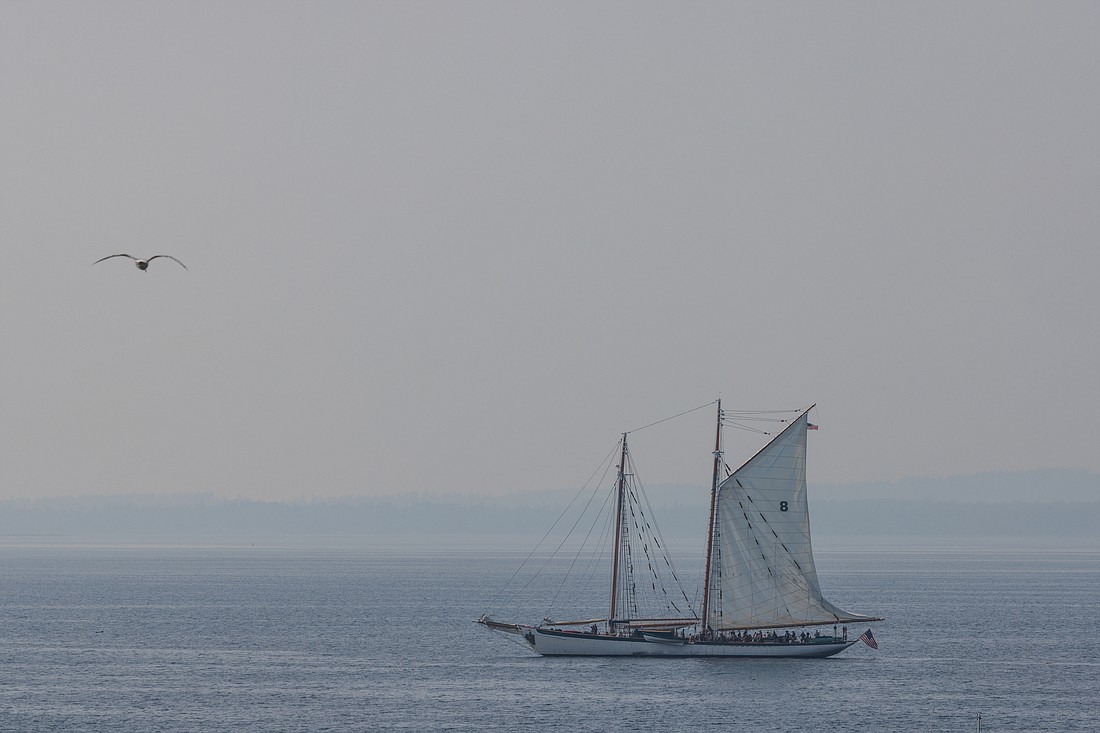 In  Bellingham Bay, the schooner Zodiac raises its sails under haze from forest fires on Sept. 11.