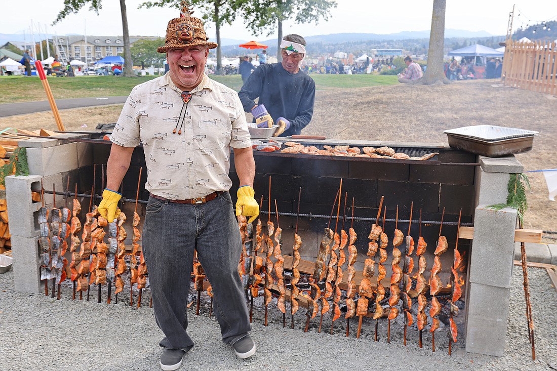 Lummi Nation fish griller Willie Lane reacts with a guffaw as coworkers razz him for nearly setting off a domino-effect cascade of Chinook salmon skewers carefully balanced near a cooking fire at SeaFeast on Sept. 17.