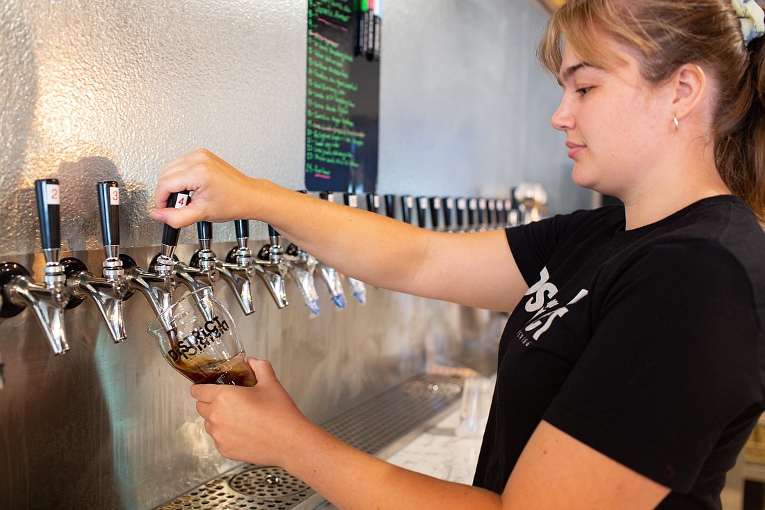 Bartender Riley Gerow pours a beer at District Brewing in Ferndale on Sept. 20.