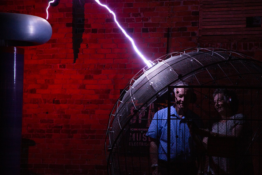 Mike Welch, left, and Martha Welch stand safely in the metal "Cage of Doom" as a large Tesla coil sends 4.6 million volts of electricity into the frame at the SPARK Museum on Sept. 25. The spectacle — known as the MegaZapper — is the main event of the museum's show on electricity.