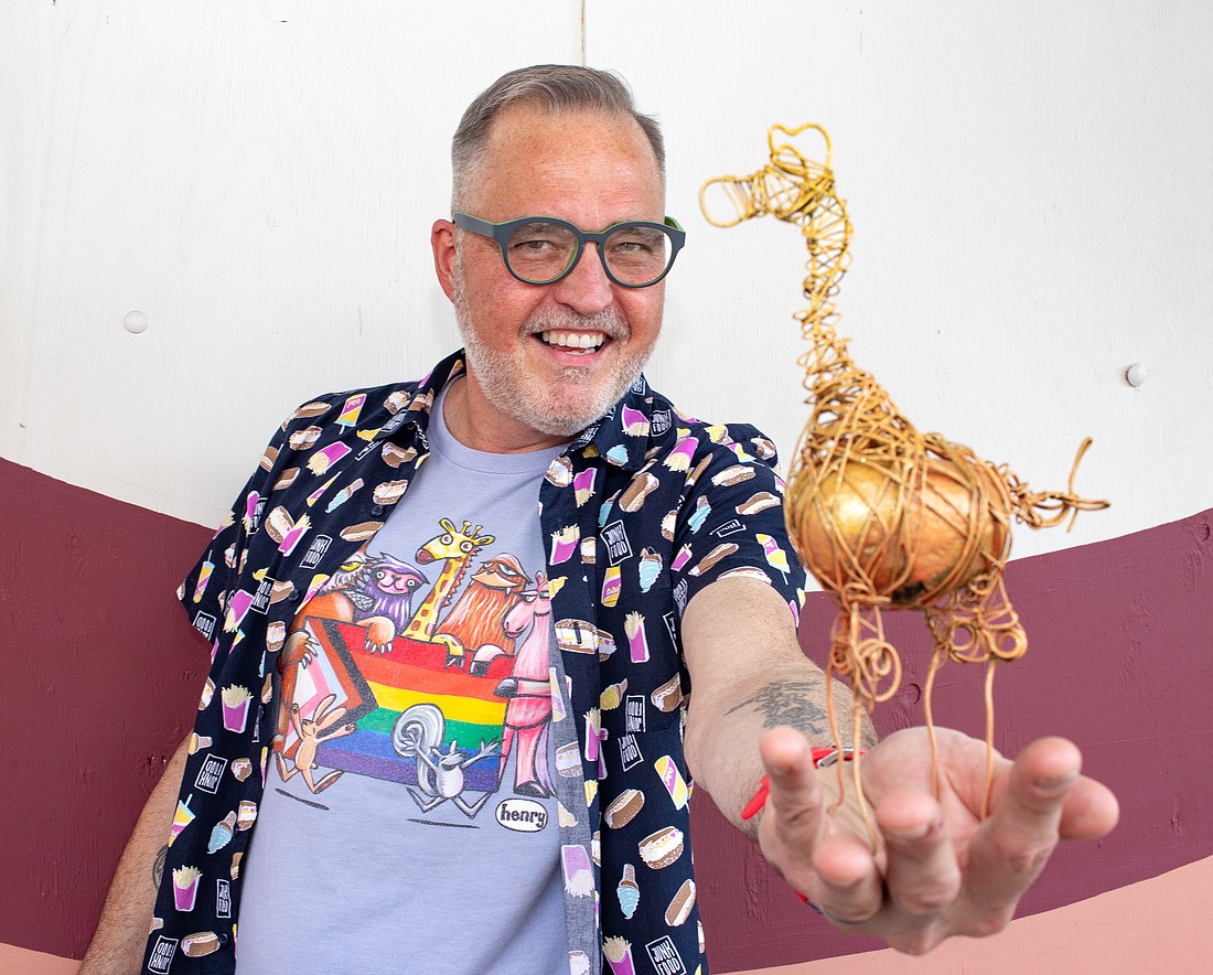 Kevin Coleman holds a rock turned giraffe statue outside of WinkWink on Sept. 29. The rock was used to smash the windows that were once behind Coleman, so he turned the dozen stones into art to auction off. He raised nearly $4,000 for Whatcom Youth Pride.