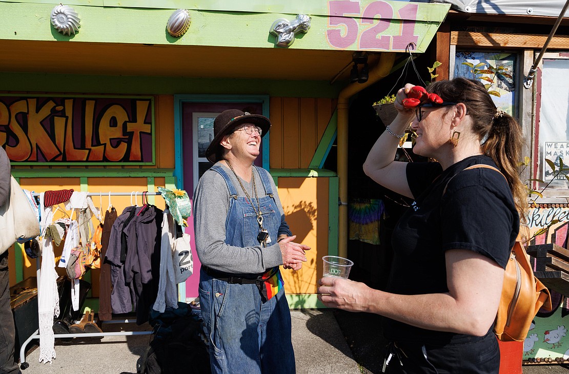 Homeskillet owner Tina White, left, laughs as Kay Danielson uses a ceramic lobster as a visor during a junk sale at the former restaurant in Bellingham on Oct. 1.