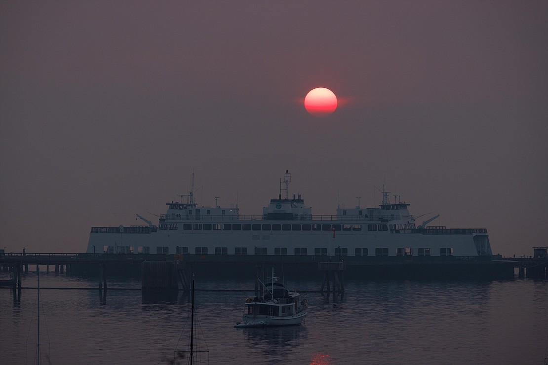 The sun begins disappearing behind Lummi Island, not visible due to wildfire smoke, as the Evergreen State ferry is docked for repairs on Oct. 18.